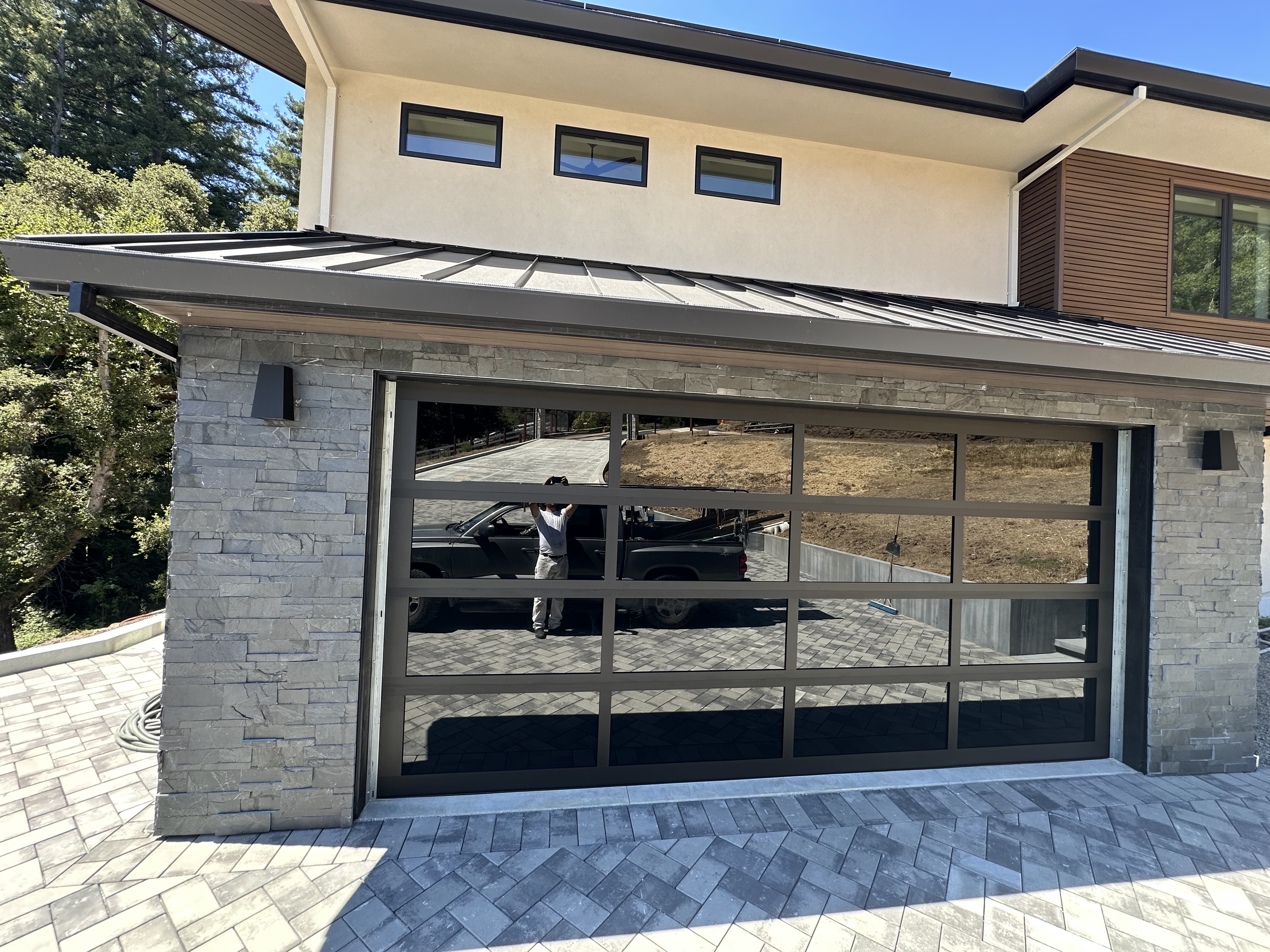Completed modern black full-view glass garage door close-up